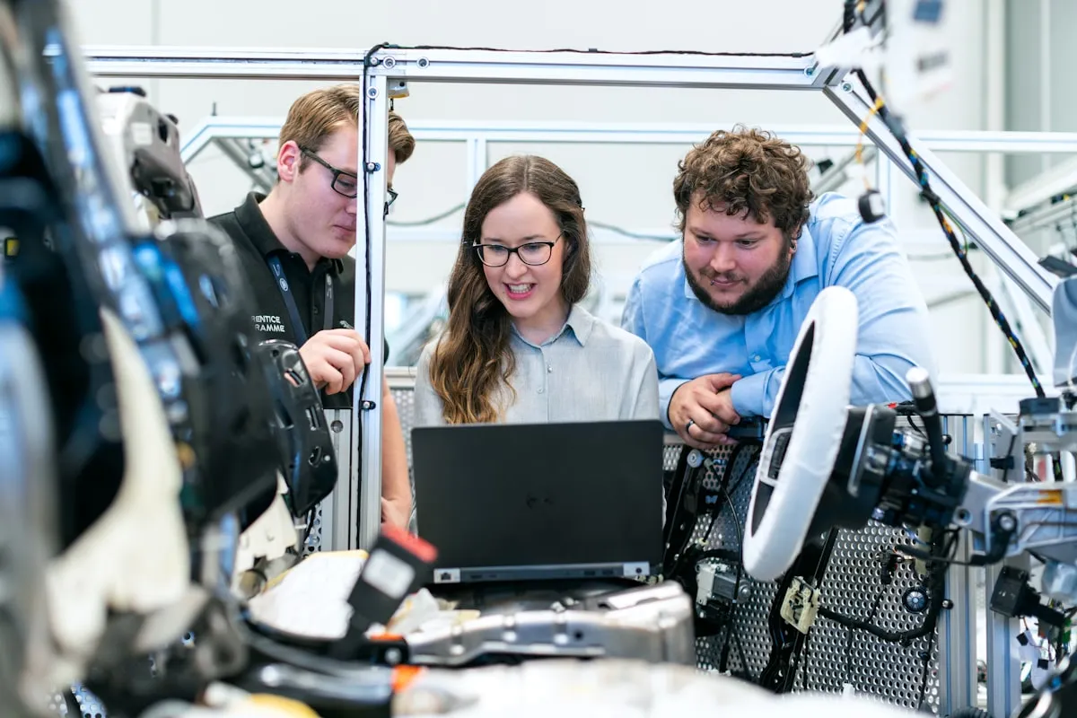 Engineers reviewing manufacturing equipment around a workstation
